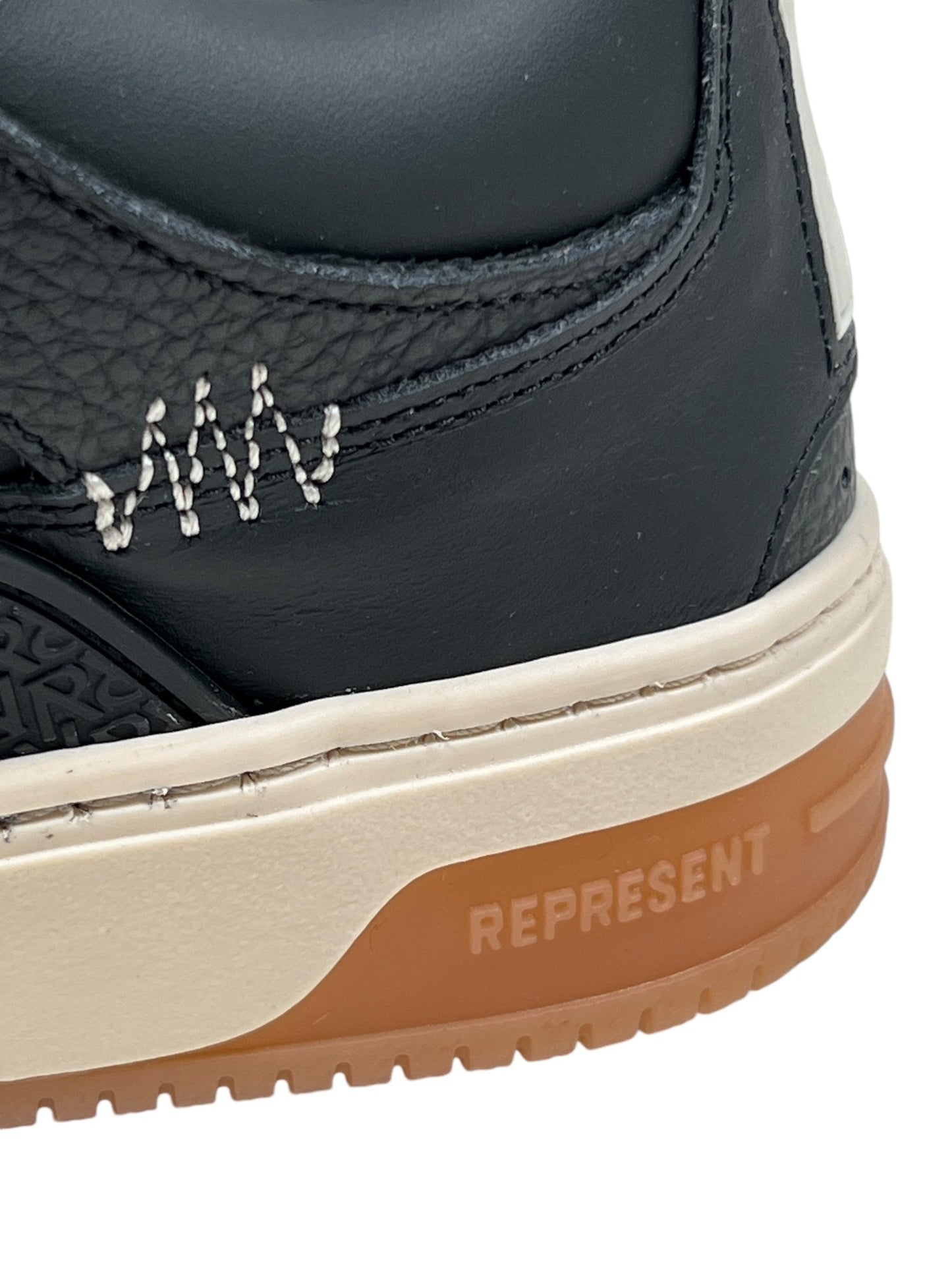 Close-up of the stylish MLM9599 Bully Black/Gum sneaker, showcasing a brown sole and decorative stitching detail with the word "REPRESENT" on the side. Its leather upper and TPU overlays enhance its bold design.