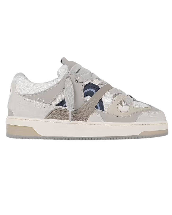 The Represent MLM9599 Bully Grey sneaker, designed by REPRESENT, is made with luxury leather and beige ballistic nylon mesh. It showcases gray tones paired with white accents and features a textured beige sole, elegantly displayed from the side against a plain white backdrop.