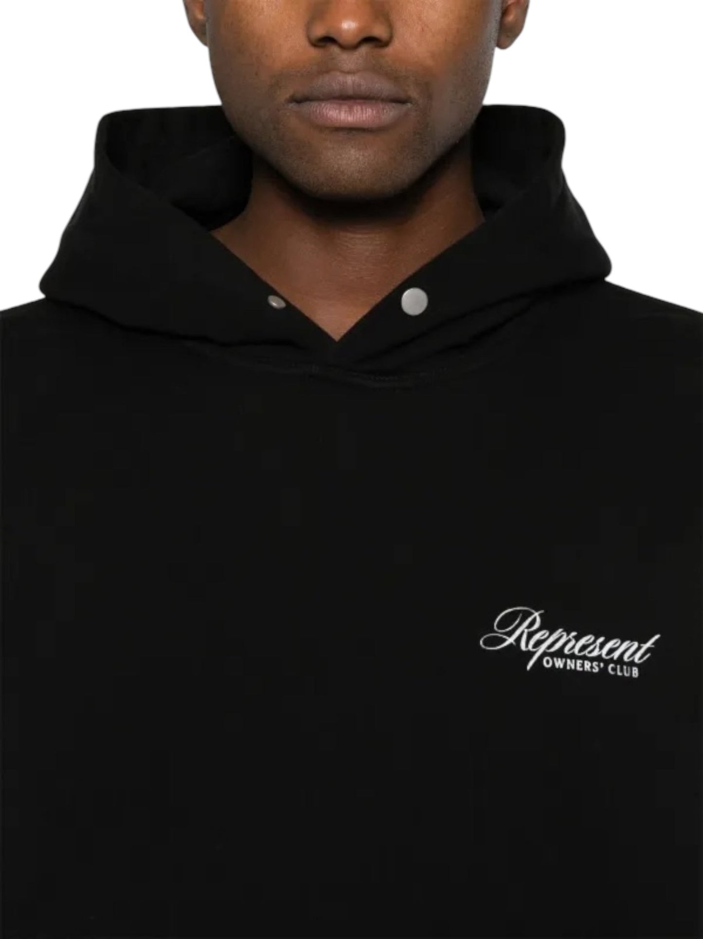 A person is wearing a Represent OCM41200 Club Script Hoodie in Black by REPRESENT, showcasing the "Represent Owners' Club" text on the front, epitomizing streetwear style with its unique buttoned collar.