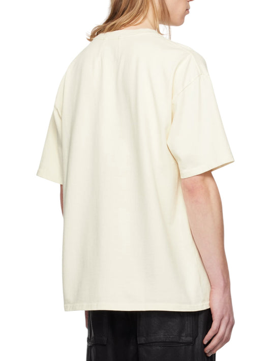 A person is seen from the back wearing a Rhude Beach-Side Tee White by RHUDE, a plain, short-sleeve T-shirt made of heavyweight cotton jersey, paired with dark pants. The tee features a rib-knit crewneck for added comfort.