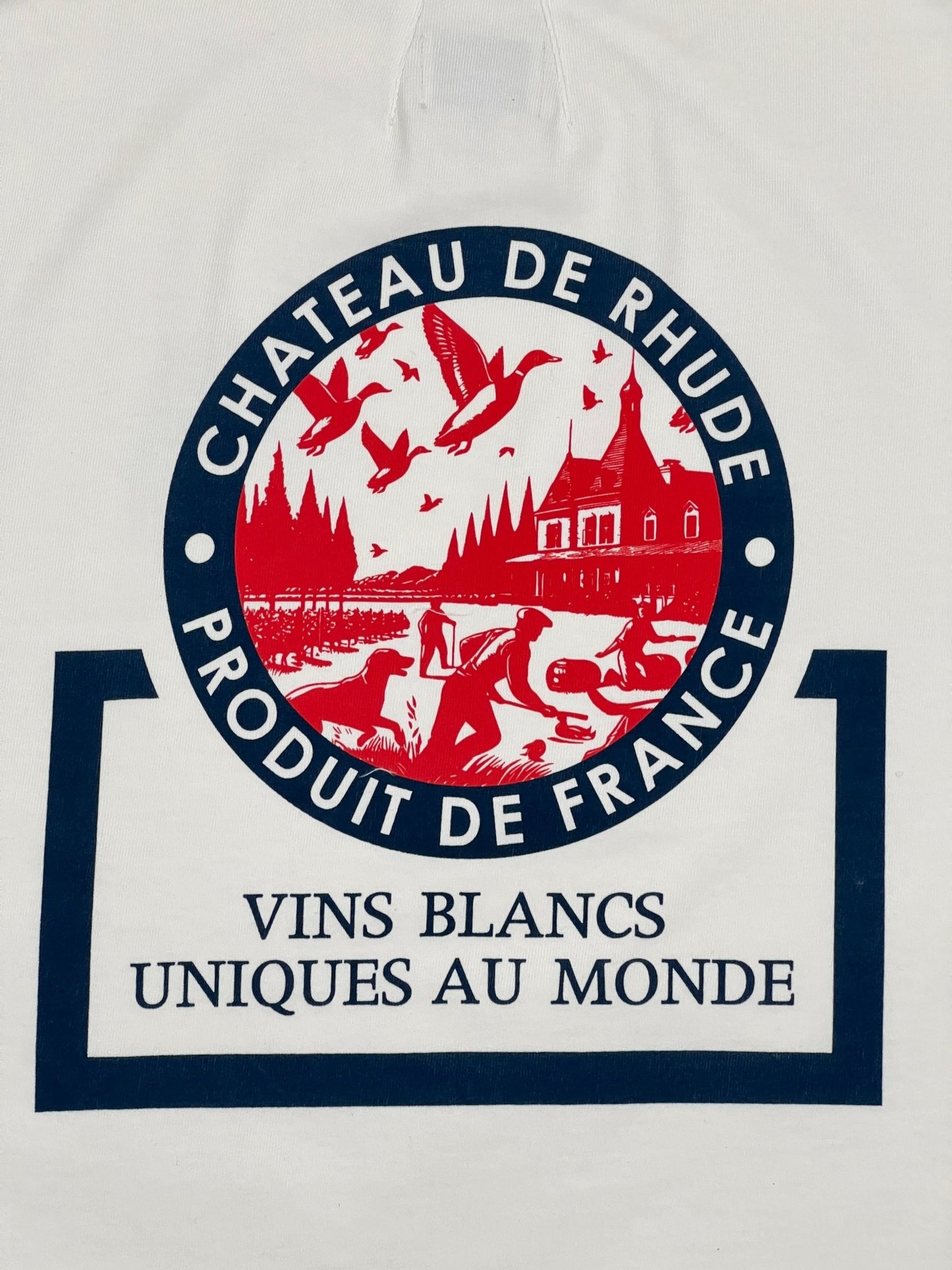 The image displays the logo for "Chateau de Rhude," featured on the Rhude Bordeaux Wine Tee in vintage white, crafted from 100% cotton by RHUDE. The design depicts a vineyard scene with flying birds and horses, encircled by the text "Produit de France" and "Vins Blancs Uniques au Monde.