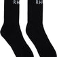 The Rhude Classic Logo Socks by RHUDE are black, calf-high, and ribbed with a white "RH" jacquard logo near the top.