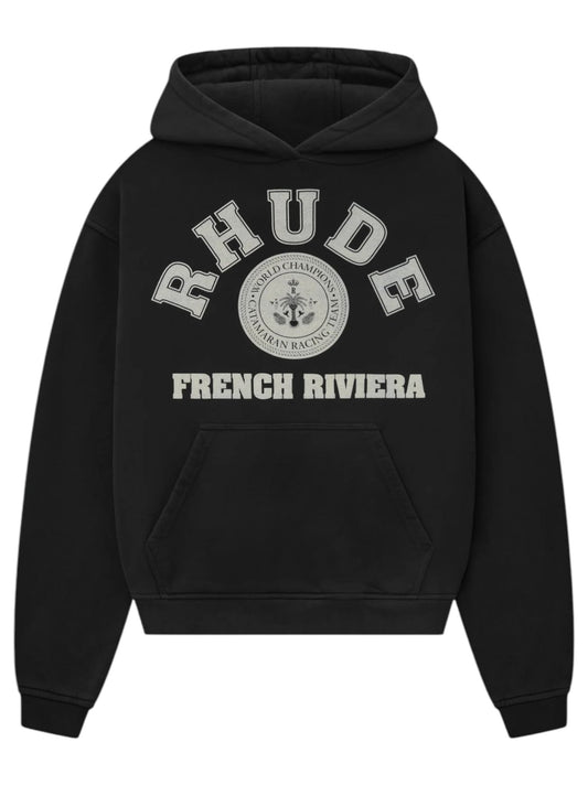 The Rhude French Riviera Hood Black from RHUDE showcases gray "RHUDE FRENCH RIVIERA" text, a racing emblem graphic with "WORLD CHAMPIONSHIP TEAM RACING" text, and has a kangaroo pocket.