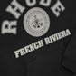 The Rhude French Riviera Hood Black by RHUDE features a kangaroo front pocket and is styled with white "RHUDE" text, a "World Champions Catamaran Racing Team" emblem, and a "FRENCH RIVIERA" design.
