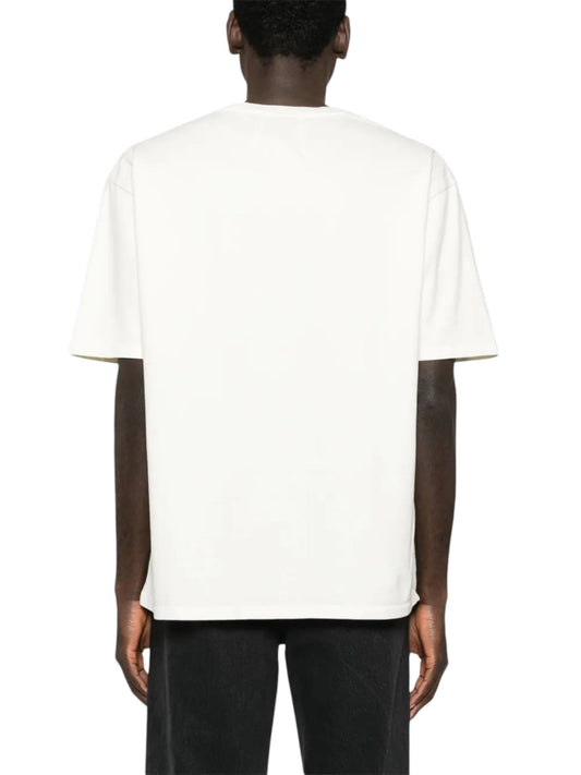 A man is seen from the back in a Rhude French Riviera Tee White by RHUDE with black pants against a white background, exuding premium craftsmanship.