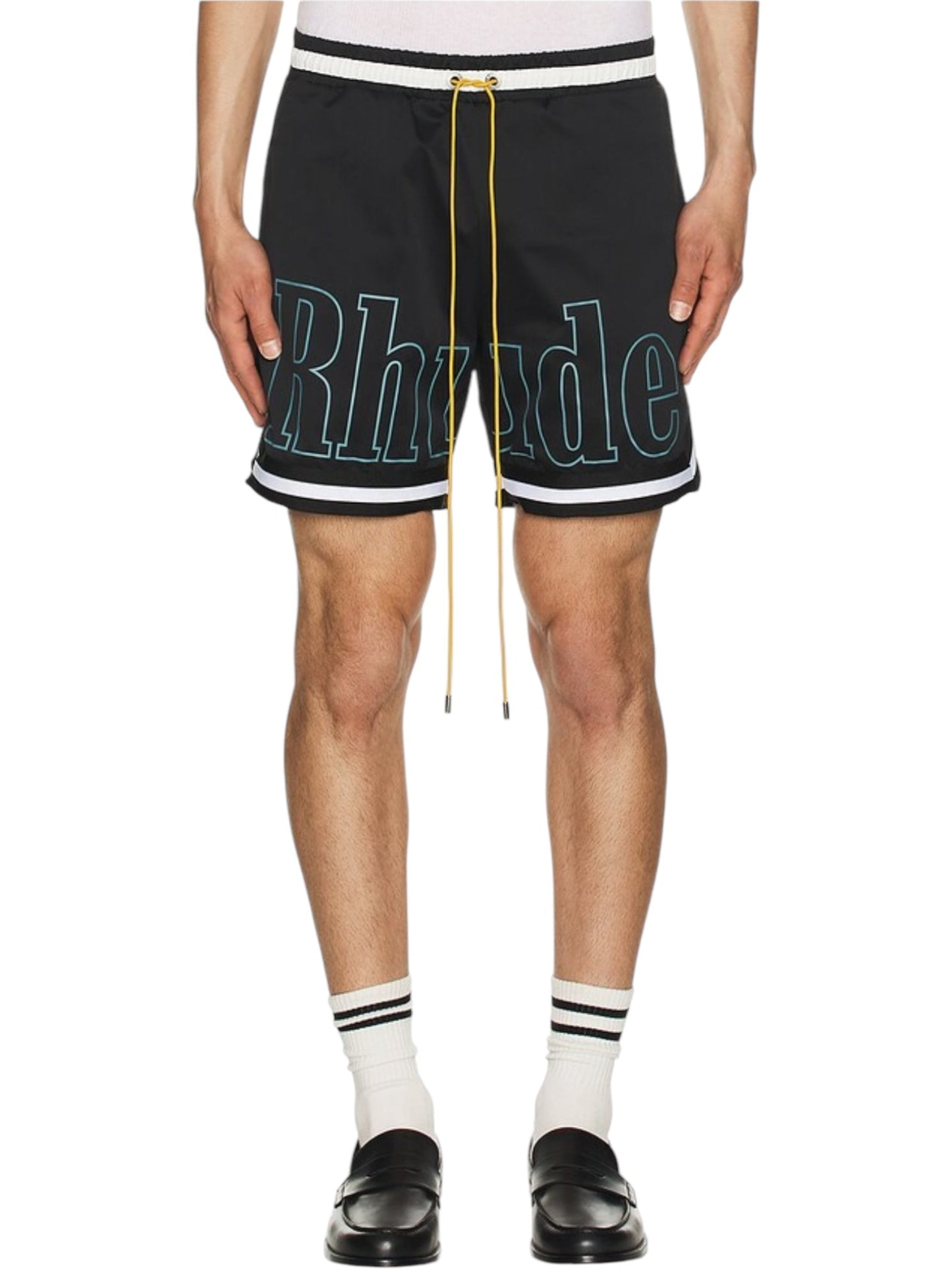 A person in Rhude Logo Basketball Swim Shorts by RHUDE, featuring large text and side pockets. Worn with white socks and black shoes, these durable polyester shorts have an elastic waistband for comfort.