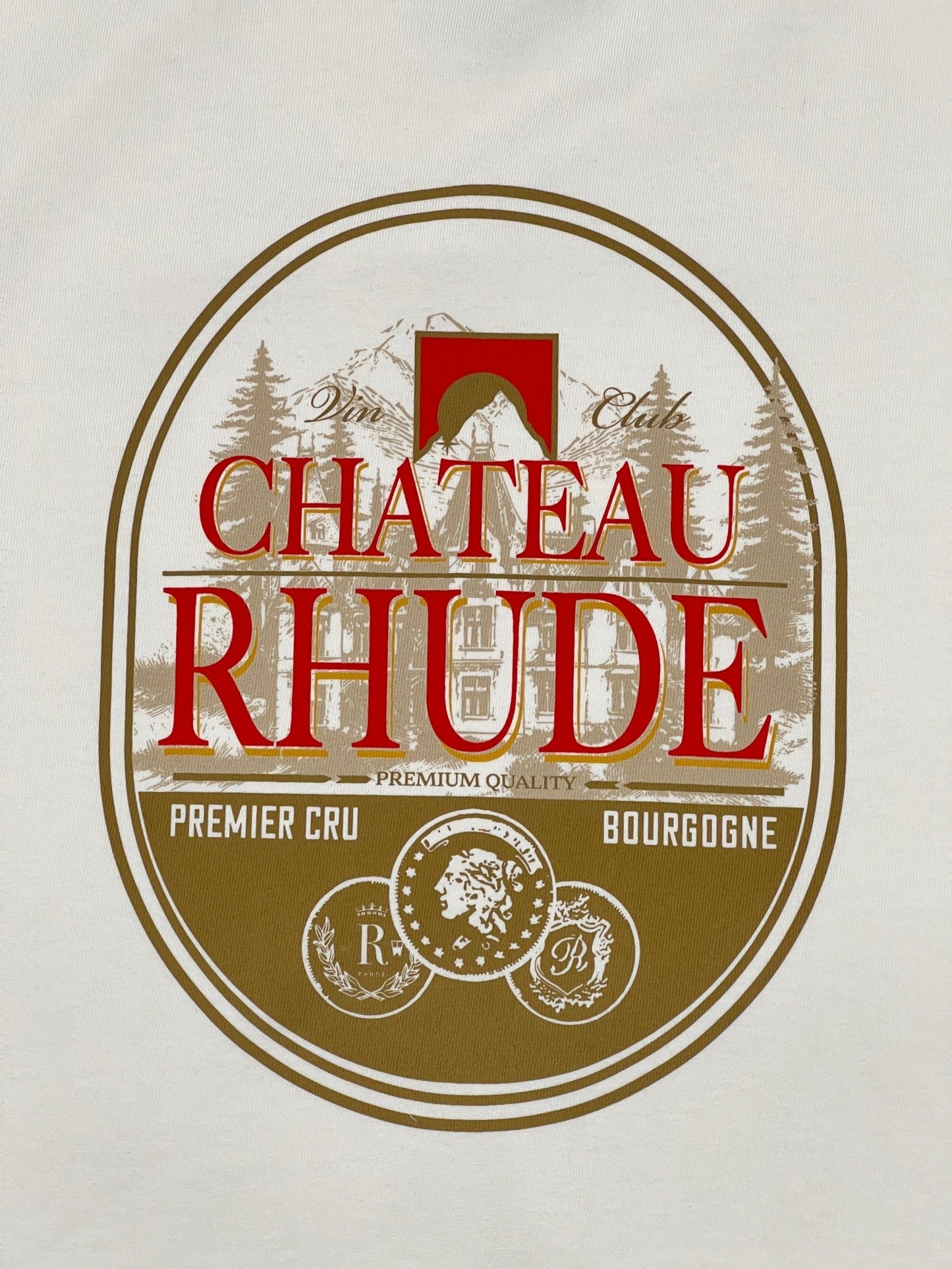 The Rhude Premier Cru Tee Vtg White features a circular label design with "Chateau Rhude" in elegant red and gold tones. Perfect for a graphic T-shirt, it showcases a mountain illustration alongside the "Premier Cru Bourgogne" text and decorative elements that capture the signature RHUDE aesthetic.