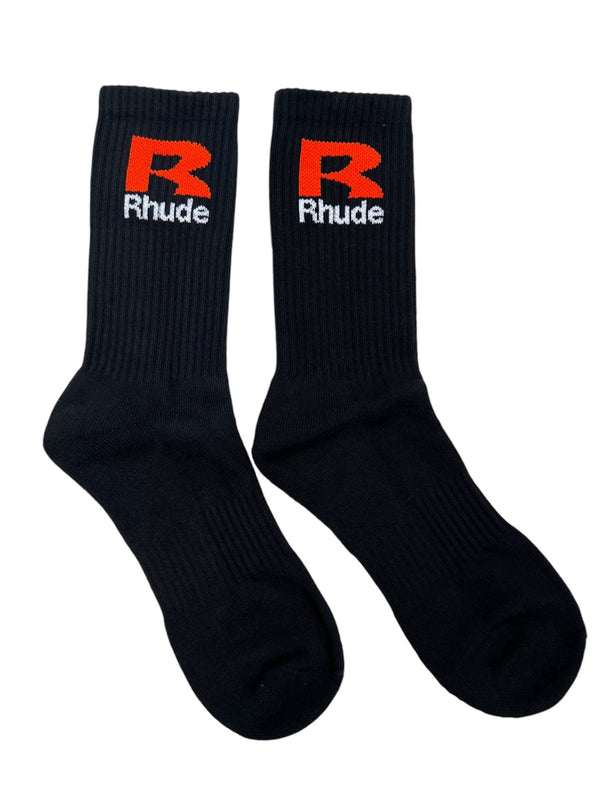 RHUDE R SOCK BLACK/ORANGE socks featuring a red and white logo on the calf, crafted from premium cotton. The socks are laid flat side by side on a white background.