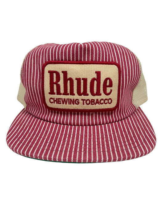 A RHUDE RED STRIPED TOBACCO TRUCKER HAT with a red and white striped cap, beige mesh back, and an adjustable back strap. It features a rectangular patch that reads "Rhude Chewing Tobacco" in red letters.