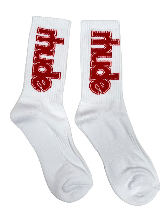 A pair of RHUDE SKI CLUB SOCK WHITE in white, featuring the word "RHUDE" in large red capital letters on the sides, crafted from 60% cotton for ultimate comfort.