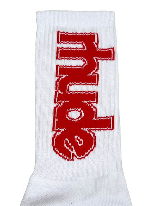 A close-up of a RHUDE SKI CLUB SOCK WHITE by RHUDE, 60% cotton, showcasing the word "PUNK" in bold red letters on a white background, oriented vertically.