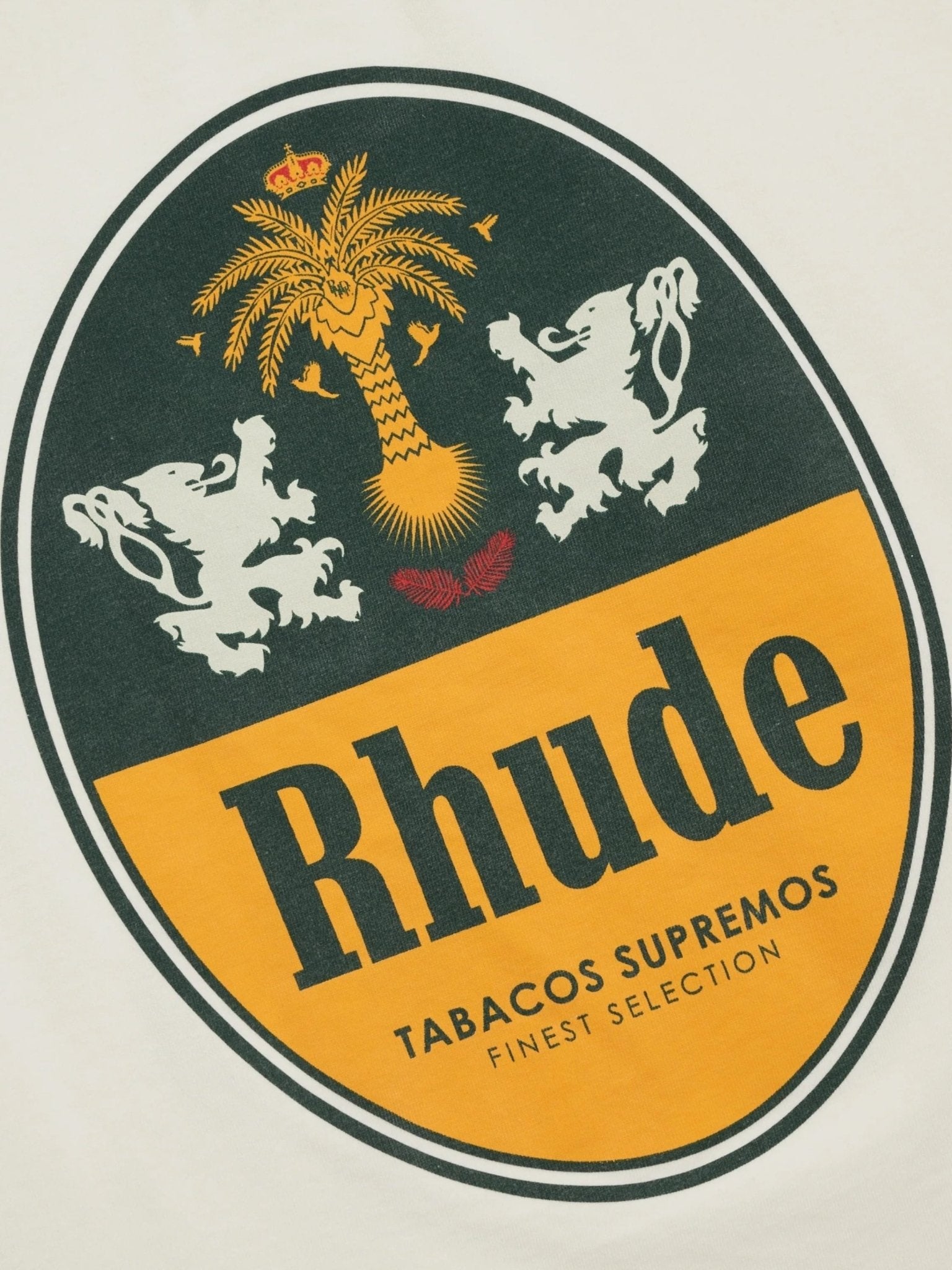 The RHUDE Tabaco Tee Vtg White features an oval logo with a palm tree, two lions, "Rhude," and "Tabacos Supremos Finest Selection" text printed on vintage wash cotton for a custom fit.