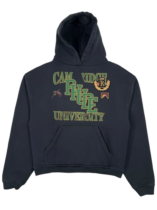 The Rhude University Hoodie Vtg Black by RHUDE displays a "Cambridge University" design with green letters and decorative elements. Made from 100% cotton, it blends classic style with comfort.