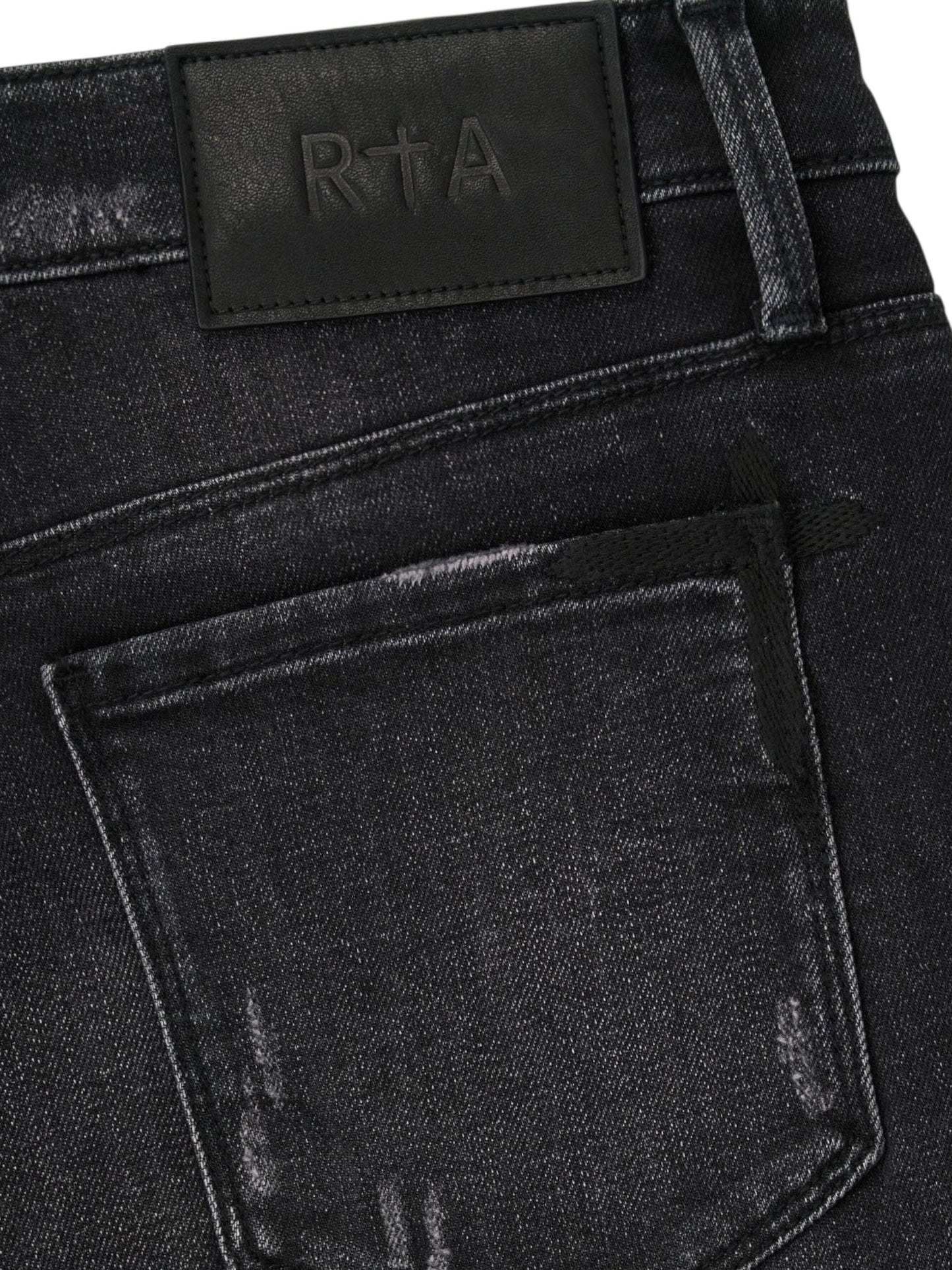 Close-up of the back pocket and waistband of RTA Clayton | Graphite Fade Black skinny jeans, crafted from high-quality denim with a black leather patch embossed with "RTA".