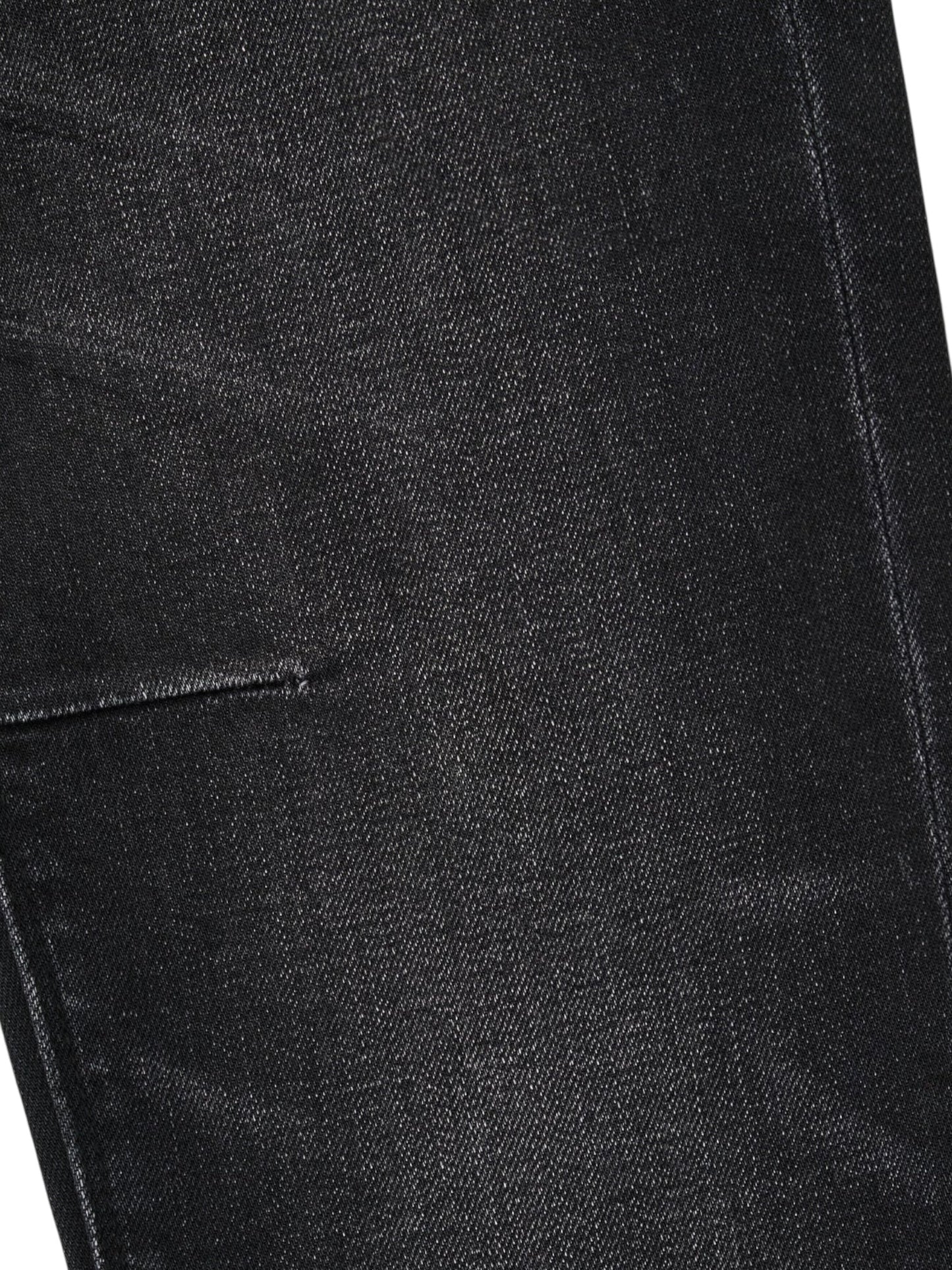 Close-up of the RTA Clayton skinny jeans in Graphite Fade Black, highlighting premium denim fabric, a seam, and part of a pocket.