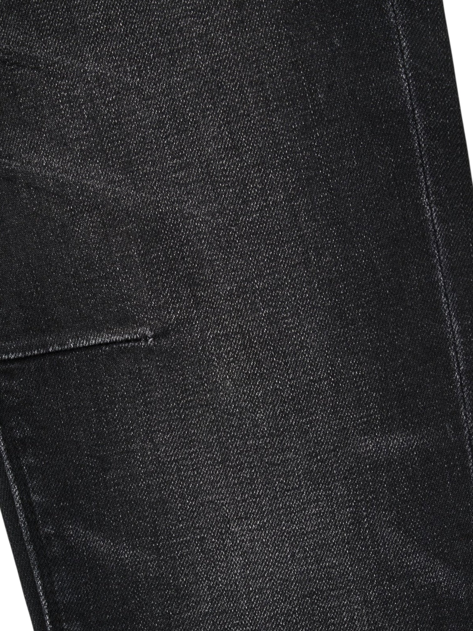 Close-up of the RTA Clayton skinny jeans in Graphite Fade Black, highlighting premium denim fabric, a seam, and part of a pocket.