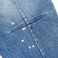 Close-up of RTA Clayton Jean Distressed White Paint Blue by RTA, highlighting a blue denim finish with a back pocket accented by small white paint splatters.