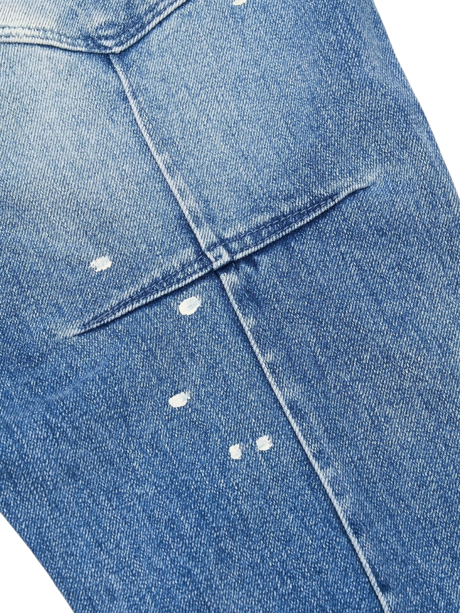 Close-up of RTA Clayton Jean Distressed White Paint Blue by RTA, highlighting a blue denim finish with a back pocket accented by small white paint splatters.