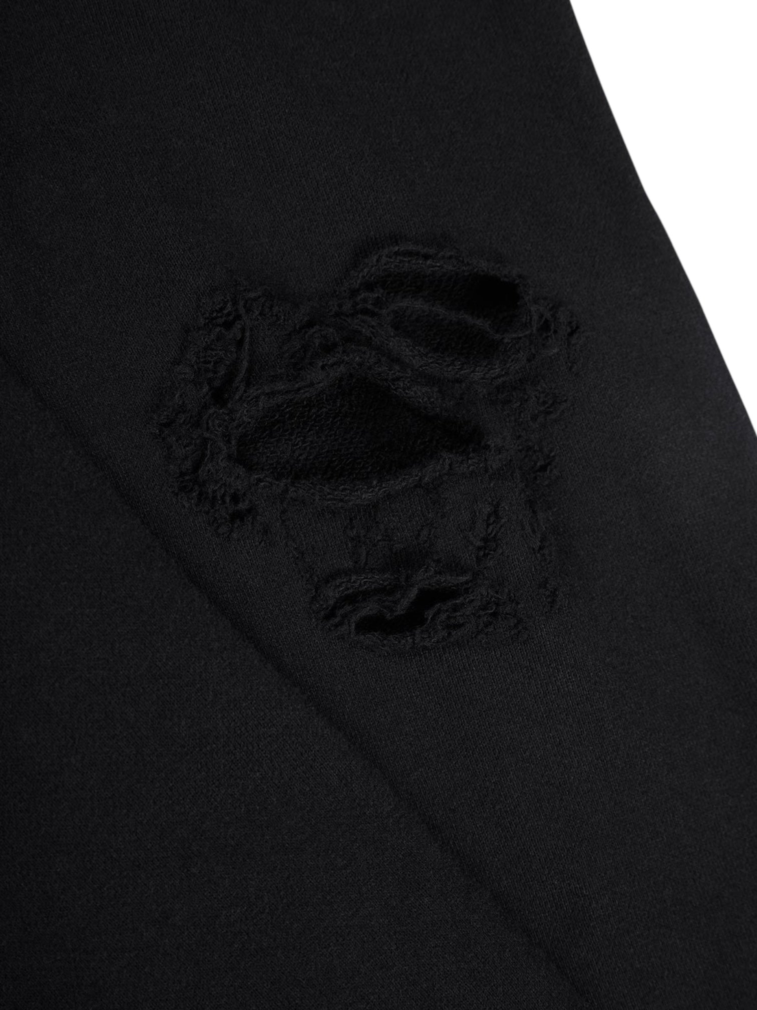 Close-up of the RTA Markus Hoody Black’s fabric, showing a ripped, frayed hole that exposes an underlayer—highlighting the edgy, distressed design of this RTA hoodie.