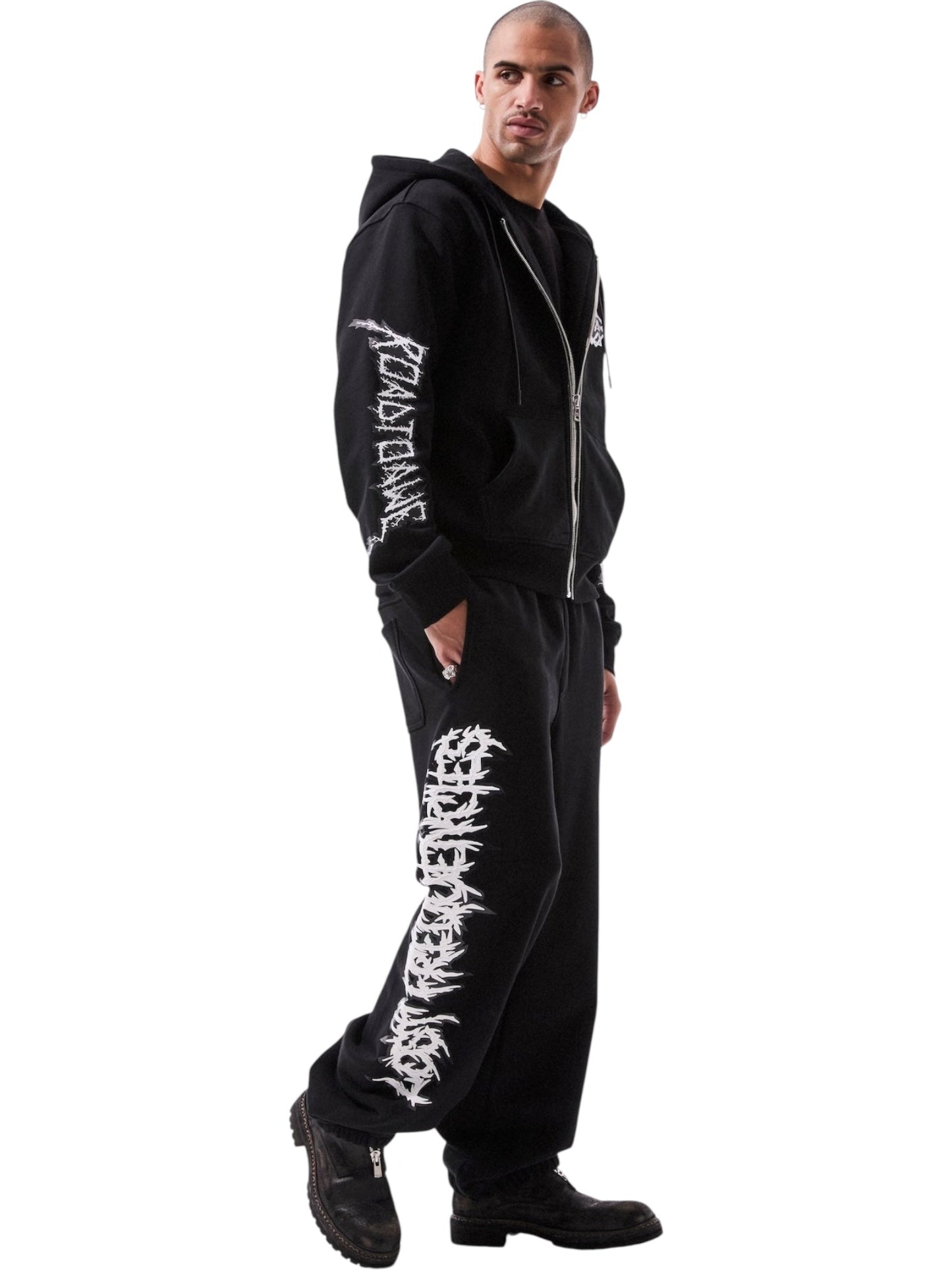 Someone sports the RTA Rafa Black Cyber Lost Frequencies hoodie and sweatpants, both featuring white graphic text designs, styled with black boots for a cyber-inspired look.