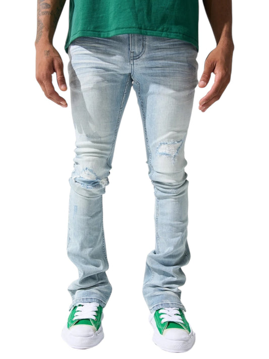 A person is wearing Serenede Azul Stacked Jeans Sky and a green shirt, paired with stylish SERENEDE sneakers in green and white, all set against a plain background.