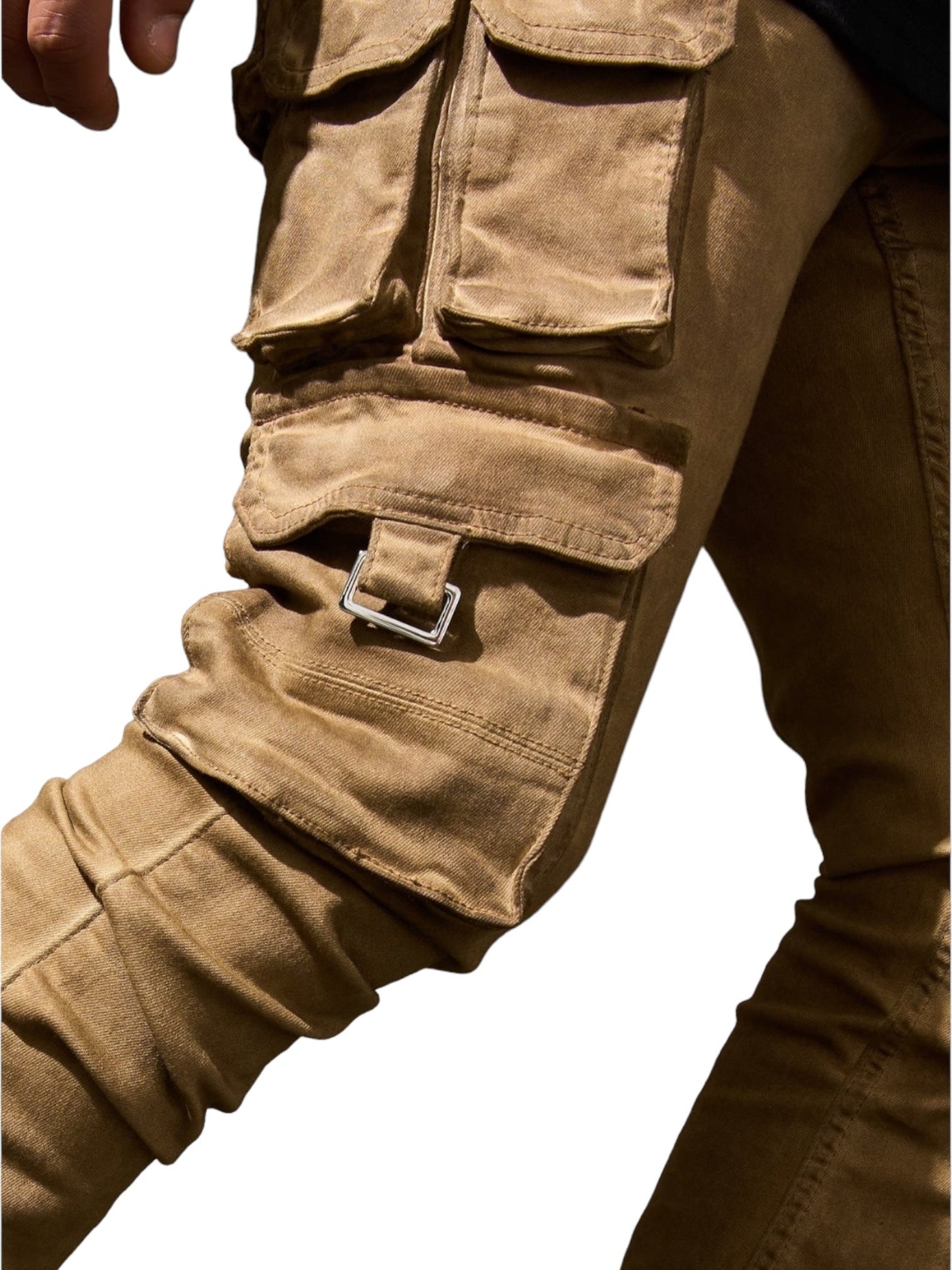 Close-up of a person wearing SERENEDE CINNAMON CARGO STACKED BRWN pants, which feature multiple pockets, a buckle on the thigh, and a leather logo patch from the brand SERENEDE.