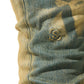 Close-up of faded blue denim fabric displaying a subtle embroidered logo, capturing the essence of SERENEDE KALAMATA JEANS OLIVE BROWN with a delicate dirty washed effect.