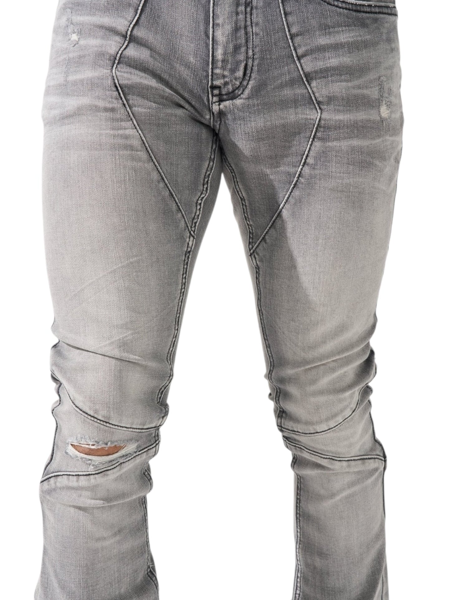 Close-up of SERENEDE's Noctis Stacked Jeans in grey, featuring visible wear and tear around the knees and seams, embodying stacked denim style.