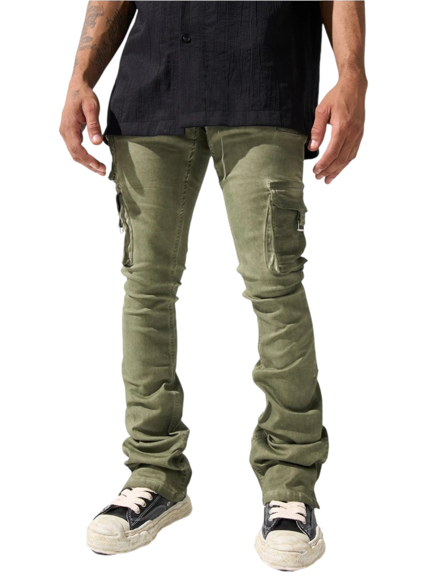 A person stands with hands by their sides, wearing Serenede Oil Cargo Stacked Jeans in olive from the brand SERENEDE, paired with a black shirt. Only the lower half is visible, highlighting stylish black and white sneakers.