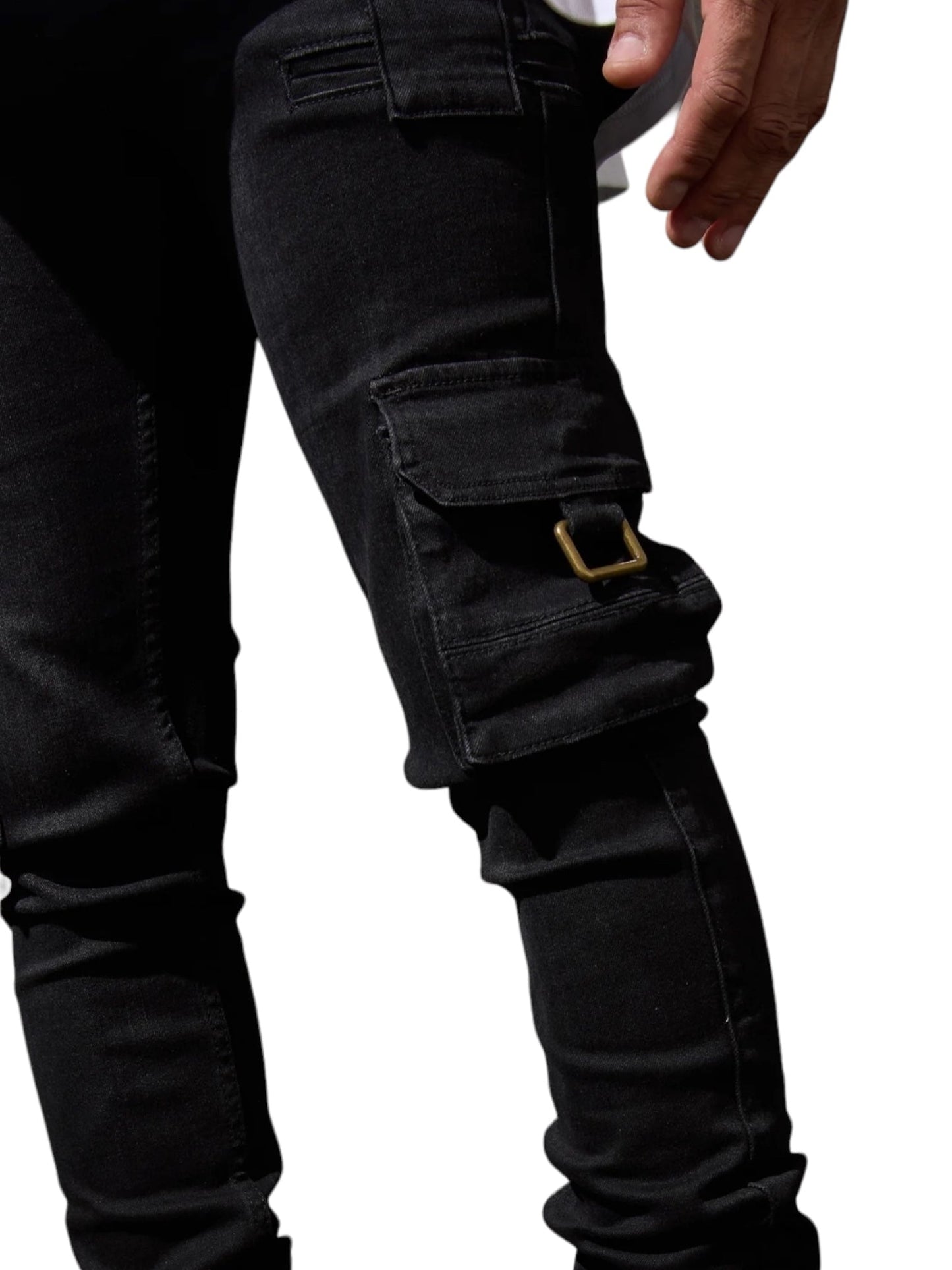 A person wearing SERENEDE PANTHERA CARGO JEANS WASHED BLK by SERENEDE with a brass buckle detail, visible from mid-thigh to waist, against a white background.