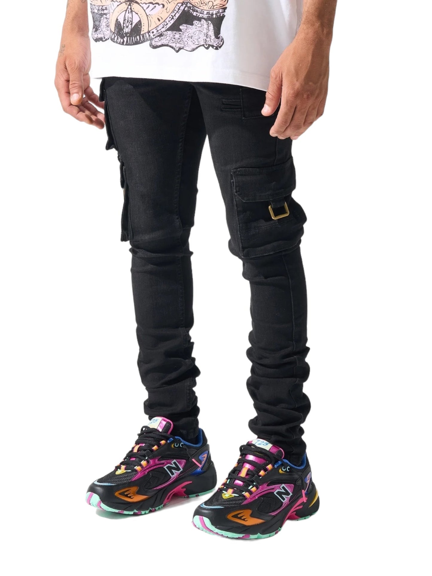 A person wearing SERENEDE PANTHERA CARGO JEANS WASHED BLK and colorful sneakers stands with their hands by their sides.