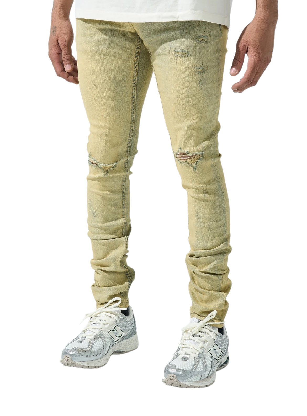 Man wearing SERENEDE SOL JEANS RISE, distressed yellow skinny jeans crafted from stretch cotton by SERENEDE, paired with white sneakers.