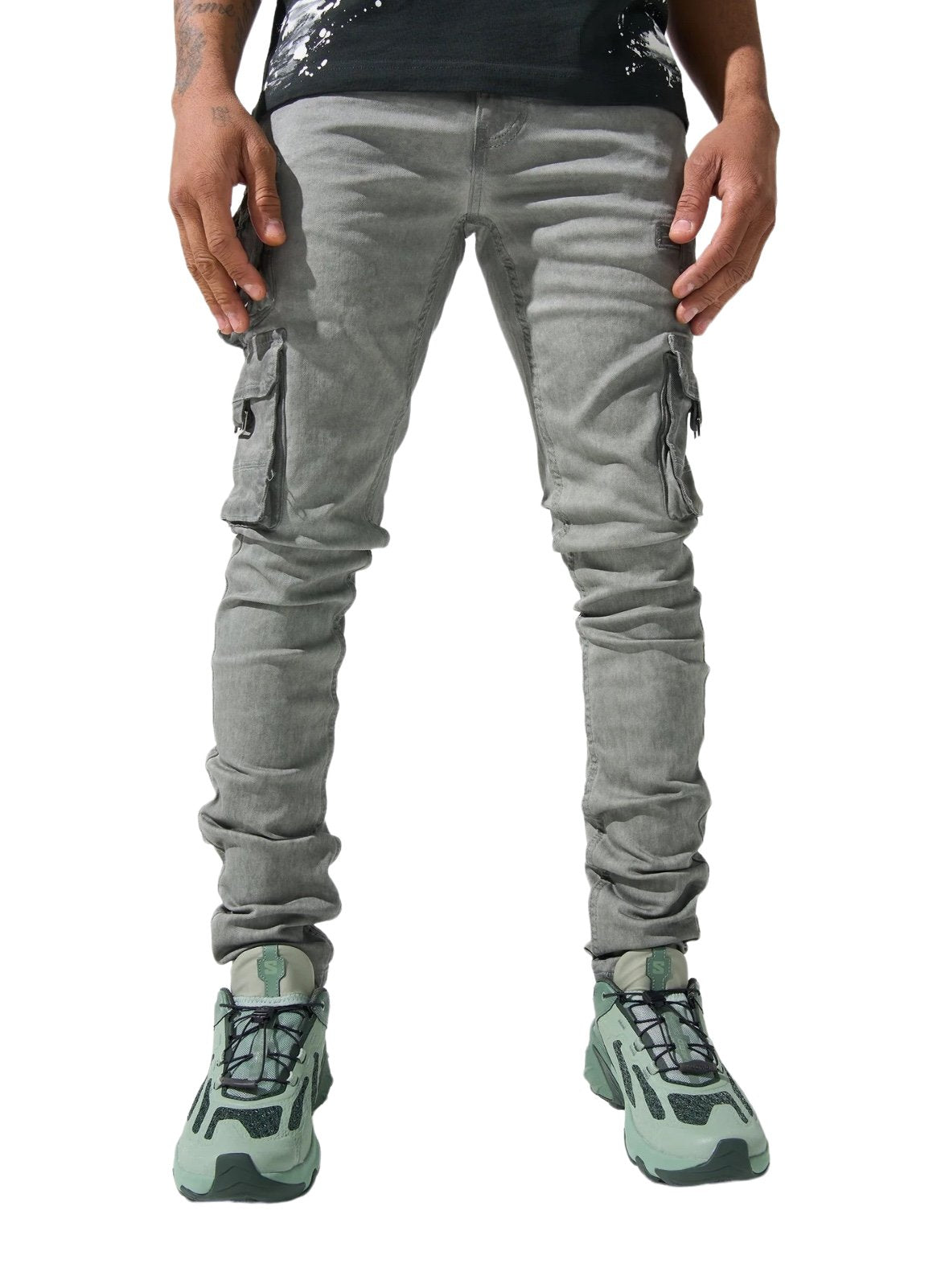 A man wearing grey SERENEDE TIMBER WOLF ARTIC GREY cargo pants and green sneakers, showcasing the lower half of his body on a white background.