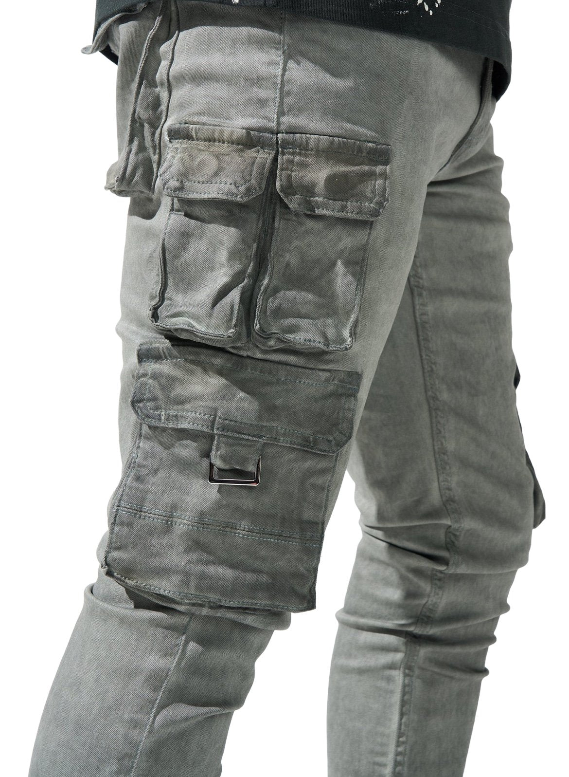 Close-up of a person wearing SERENEDE TIMBER WOLF ARTIC GREY cargo pants with multiple pockets and a buckle detail, showing only the midsection and legs.