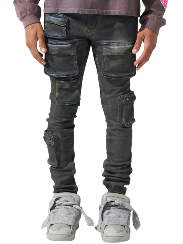 Person wearing SERENEDE WAVE CARGO JEANS from SERENEDE in atlantic dark blue with multiple pockets and gray sneakers, standing against a white background.