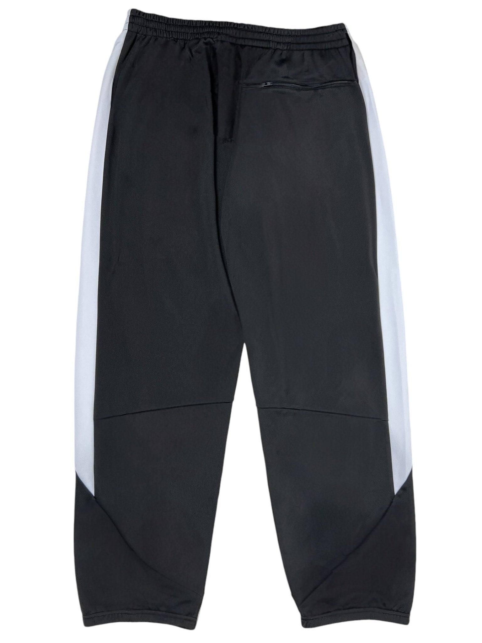The Sinclair SMB65 Tech Logo Track Pant Black by SINCLAIR boasts a sleek black athletic design with white side panels, made from 100% polyester for comfort. It features an elastic waistband for a perfect fit and a back zippered pocket for functionality, completed with a black embroidered logo.