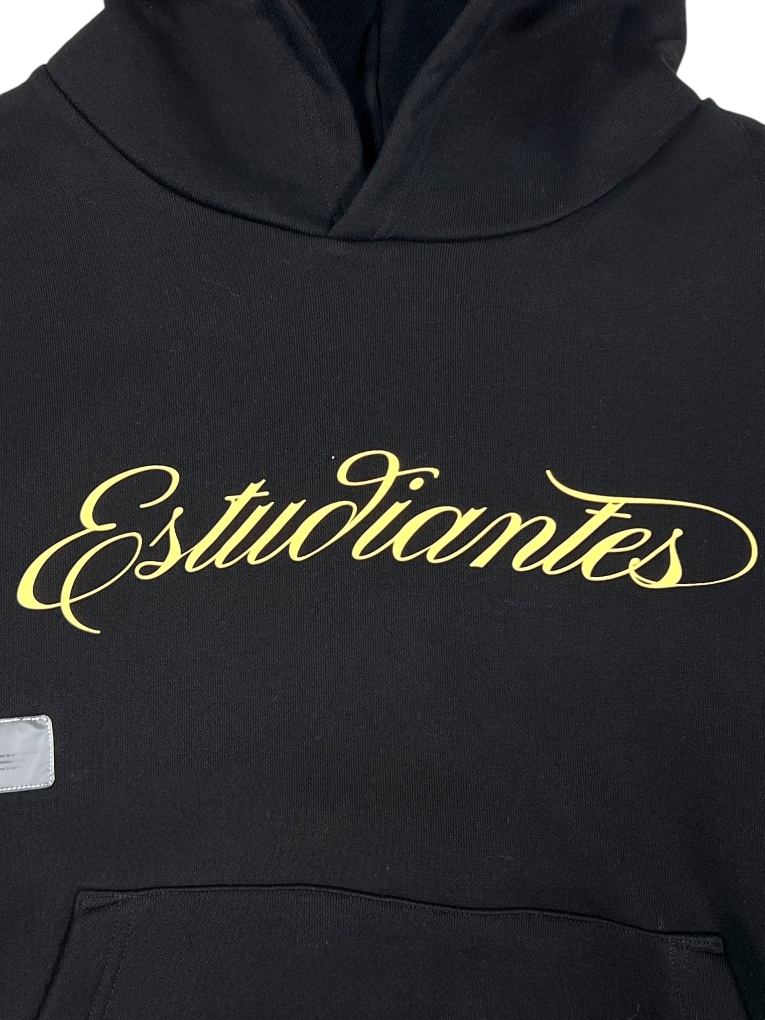 Enjoy comfort and style with the STUDENTS Estudiantes Pullover Hoodie in black, made from 100% cotton. "Estudiantes" is elegantly scripted in yellow across the chest, making it a perfect standout piece for students.