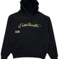 The Students Estudiantes Pullover Hood in black, by STUDENTS, features "Estudiantes" in gold cursive on the front. It's made from 100% cotton and includes a kangaroo pocket with a small rectangular label on the left side.