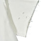 Close-up of the UNTITLED ARTWORKS Untitled Artworks Crewneck Short Sleeve Cream, a 100% cotton oversized t-shirt with a white short sleeve, unfinished frayed hem, and three small holes near the seam.