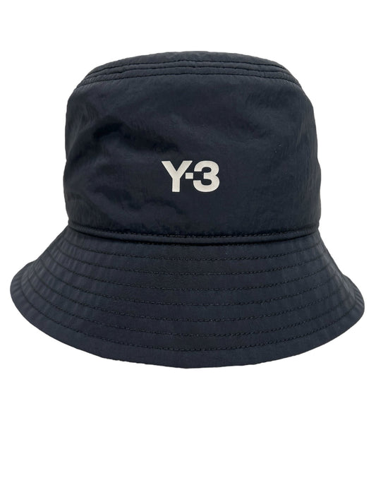 A black bucket hat crafted from polyamide, featuring "Y-3" printed in white on the front. The product is the Y-3 IY4087 STRP B HAT BLACK BLACK OSFM from ADIDAS x Y-3.