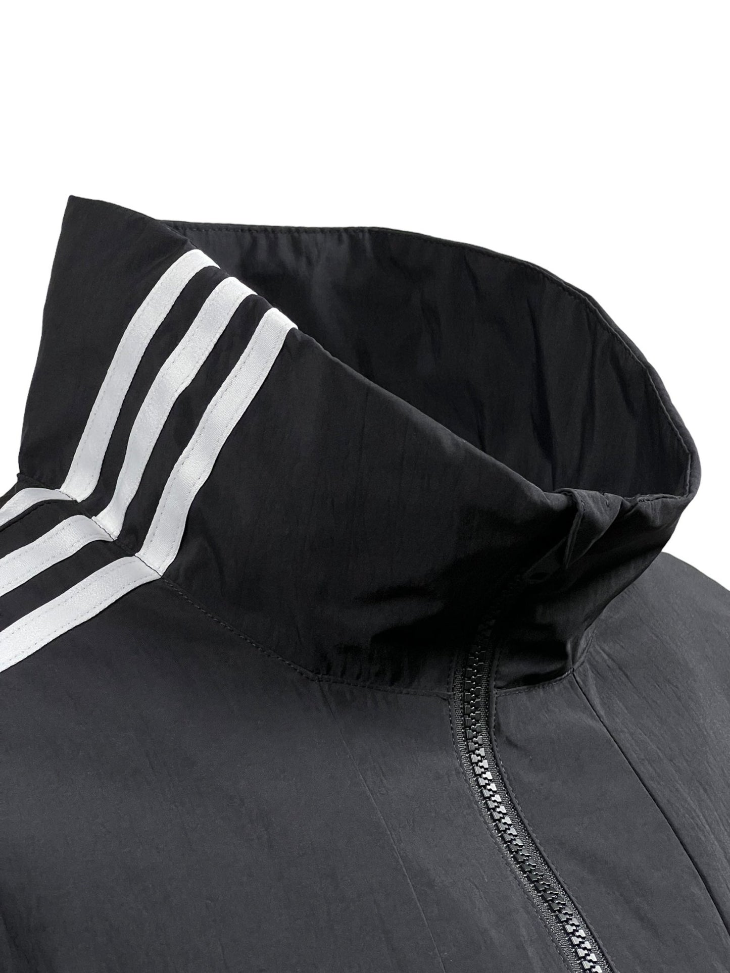 Close-up of an oversized black ADIDAS x Y-3 Y-3 JD9796 3S NYL HZ BLACK jacket with a high collar and white stripes on the left shoulder. The jacket features a zipper partially visible at the bottom.