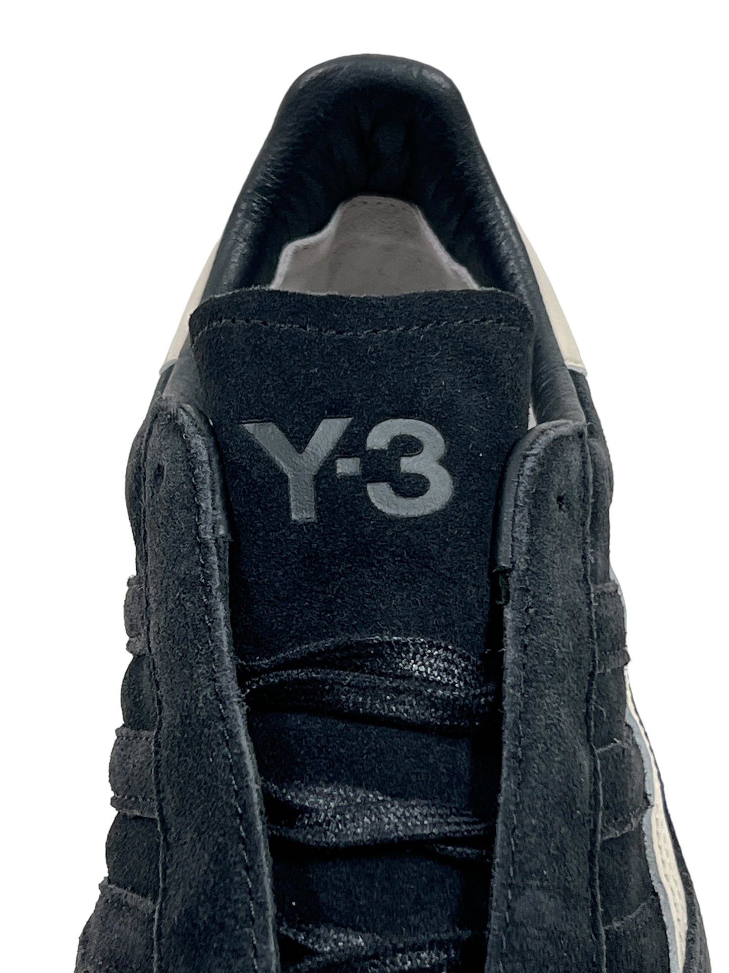 A close-up of the ADIDAS x Y-3 JH8925 Gazelle Black/Alumin sneaker highlights "Y-3" branding on the tongue and textured laces, reflecting the classic elegance of Gazelle style.