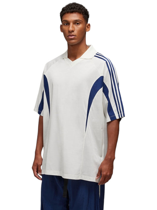 An individual dressed in an ADIDAS x Y-3 JM3222 SS CTLN Tee in white, featuring loose fit and blue vertical three stripes on the sleeves.