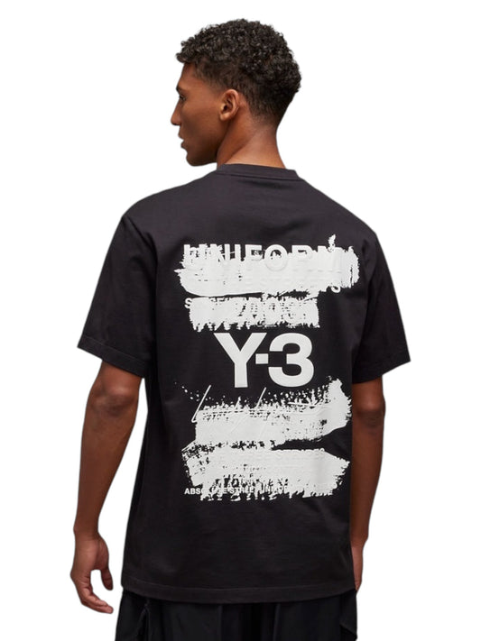 The man is wearing an ADIDAS x Y-3 JN4879 U GFX SS Tee Black, made from soft cotton fabric and featuring Y-3 designs with abstract white text and graphics on the back.