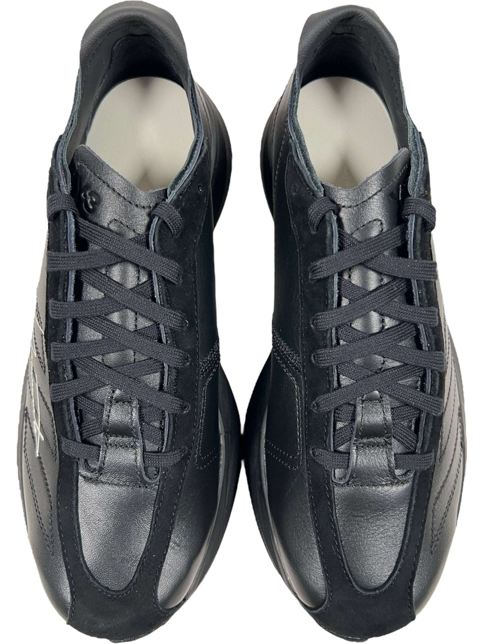 The ADIDAS x Y-3 JR4205 Y-3 ADIOS PRO 3.0 Black/Black sneakers feature black leather and laces, inspired by Yohji Yamamoto's design, shown from above on a white background.