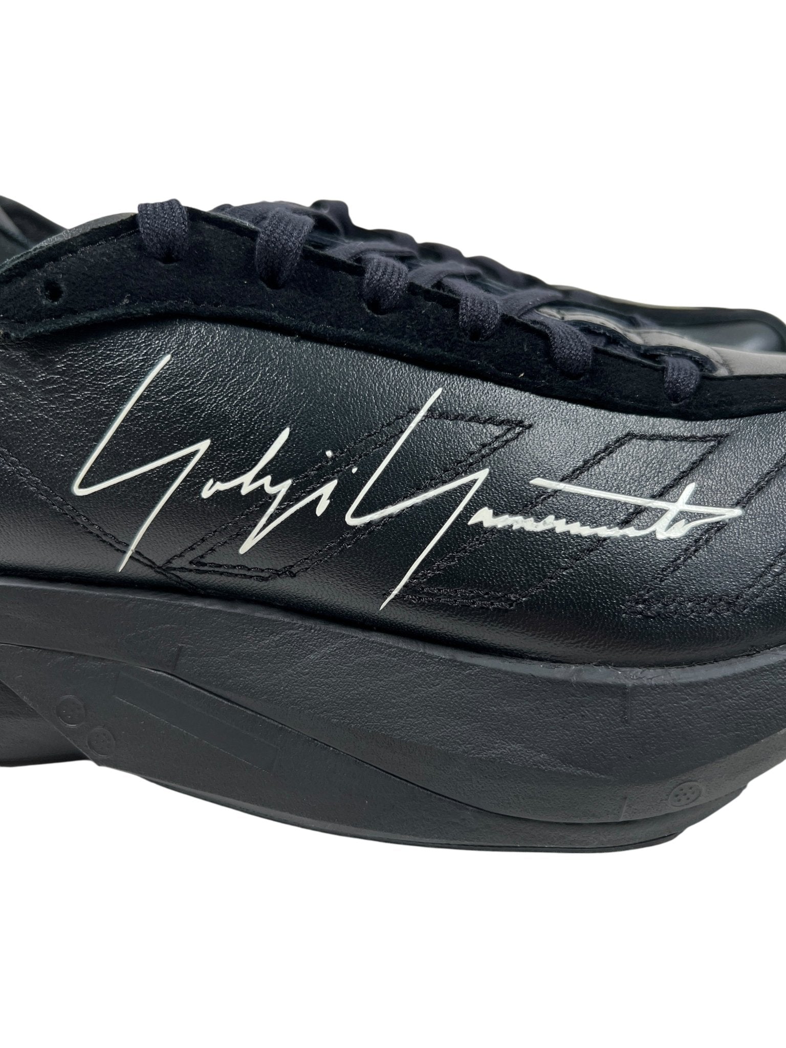 The ADIDAS x Y-3 JR4205 Y-3 ADIOS PRO 3.0 Black/Black is a racing shoe with a thick sole, black laces, and Yohji Yamamoto's white signature on the side—part of the cutting-edge Y-3 Adios Pro collection.