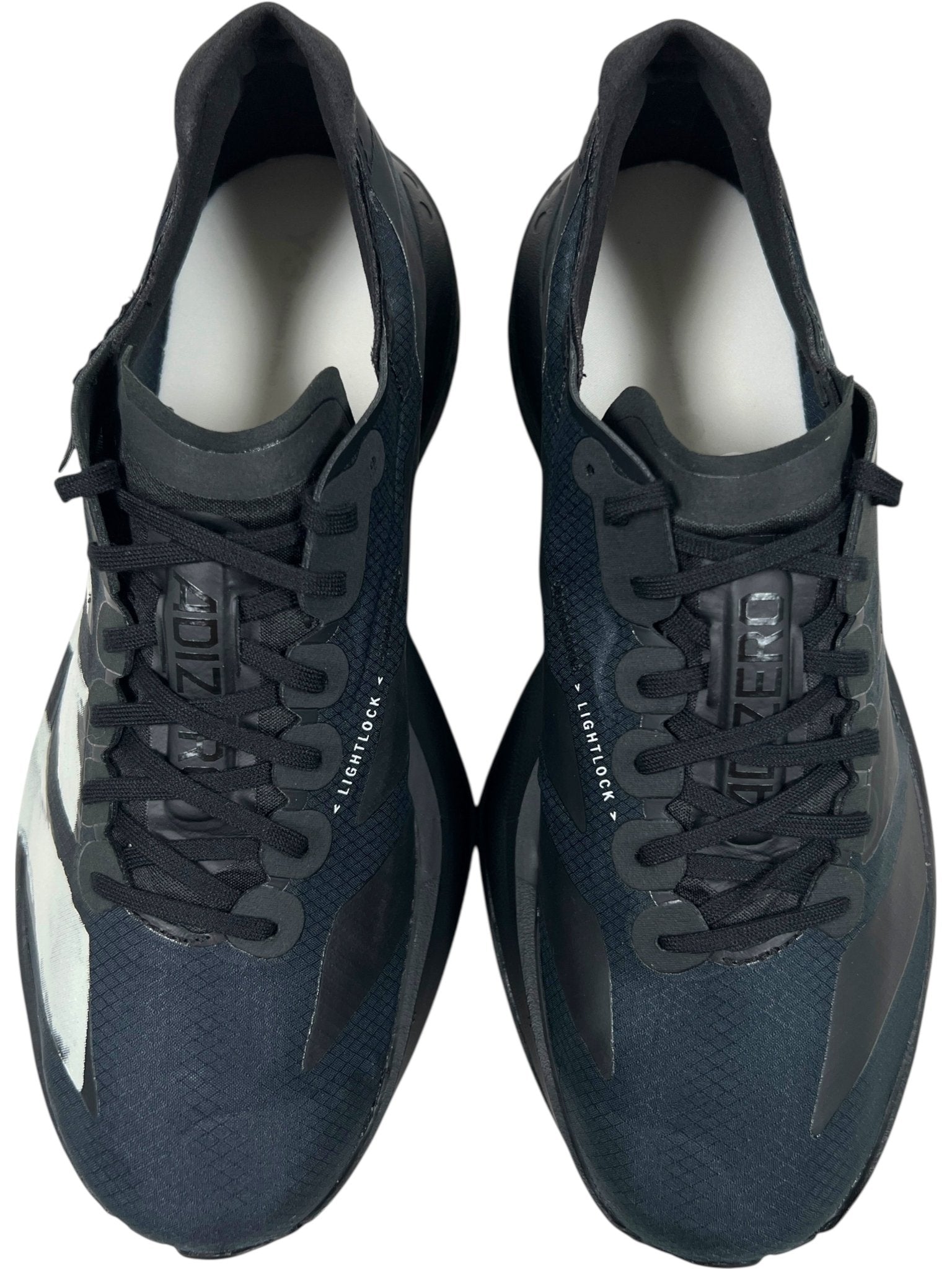A pair of ADIDAS x Y-3 JR6655 ADIOS PRO 4 M in Black/Black-CWhite viewed from above, featuring "ADIZERO" and "LIGHTLOCK" branding on the tongue and sides, with advanced Lightstrike Pro cushioning for optimal performance.