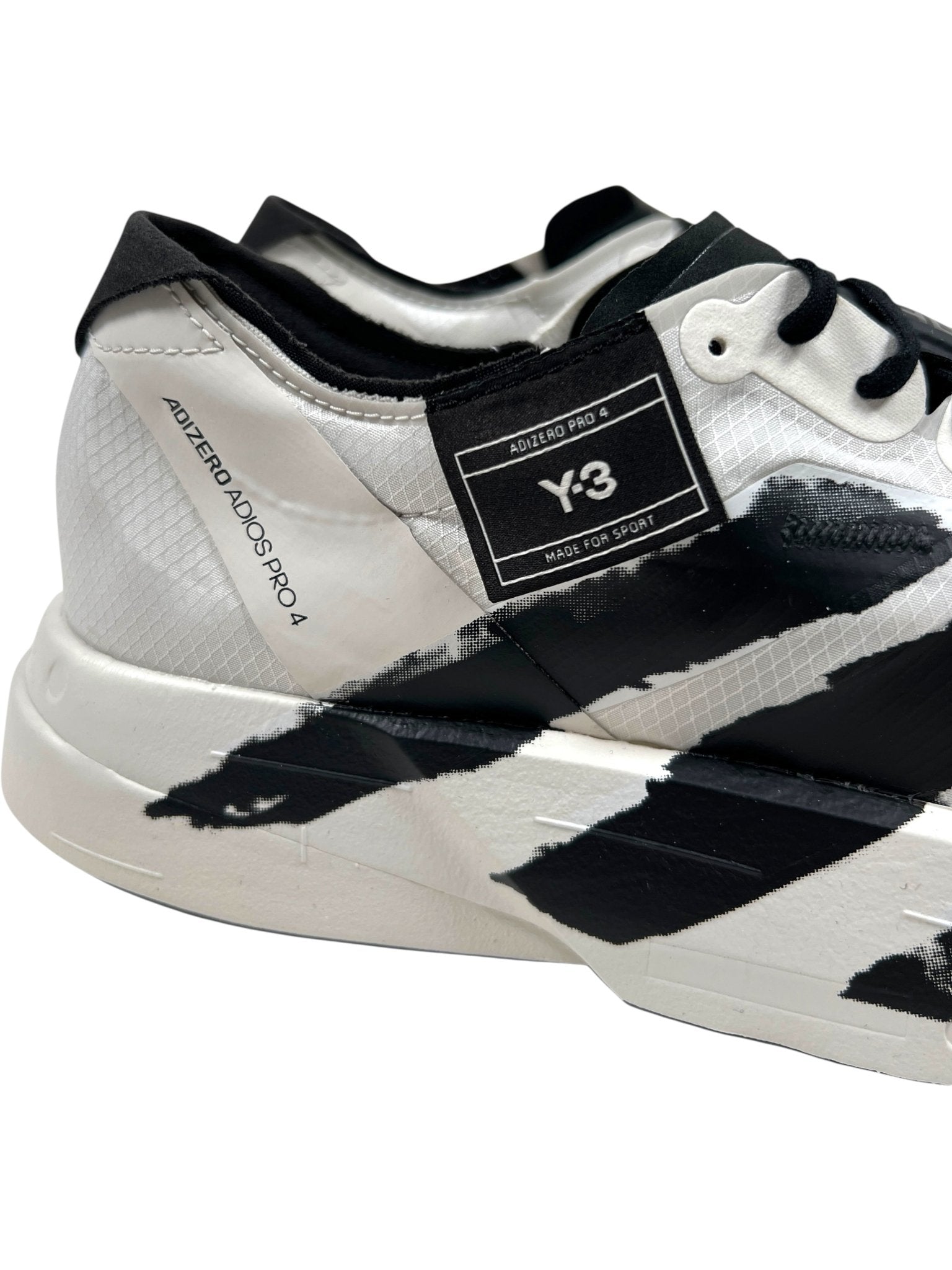 A close-up of the ADIDAS x Y-3 JR6656 Y-3 Adios Pro 4 M in Orbgry/Black highlights its abstract design, side branding, and responsive Lightstrike Pro cushioning for premium style and performance.