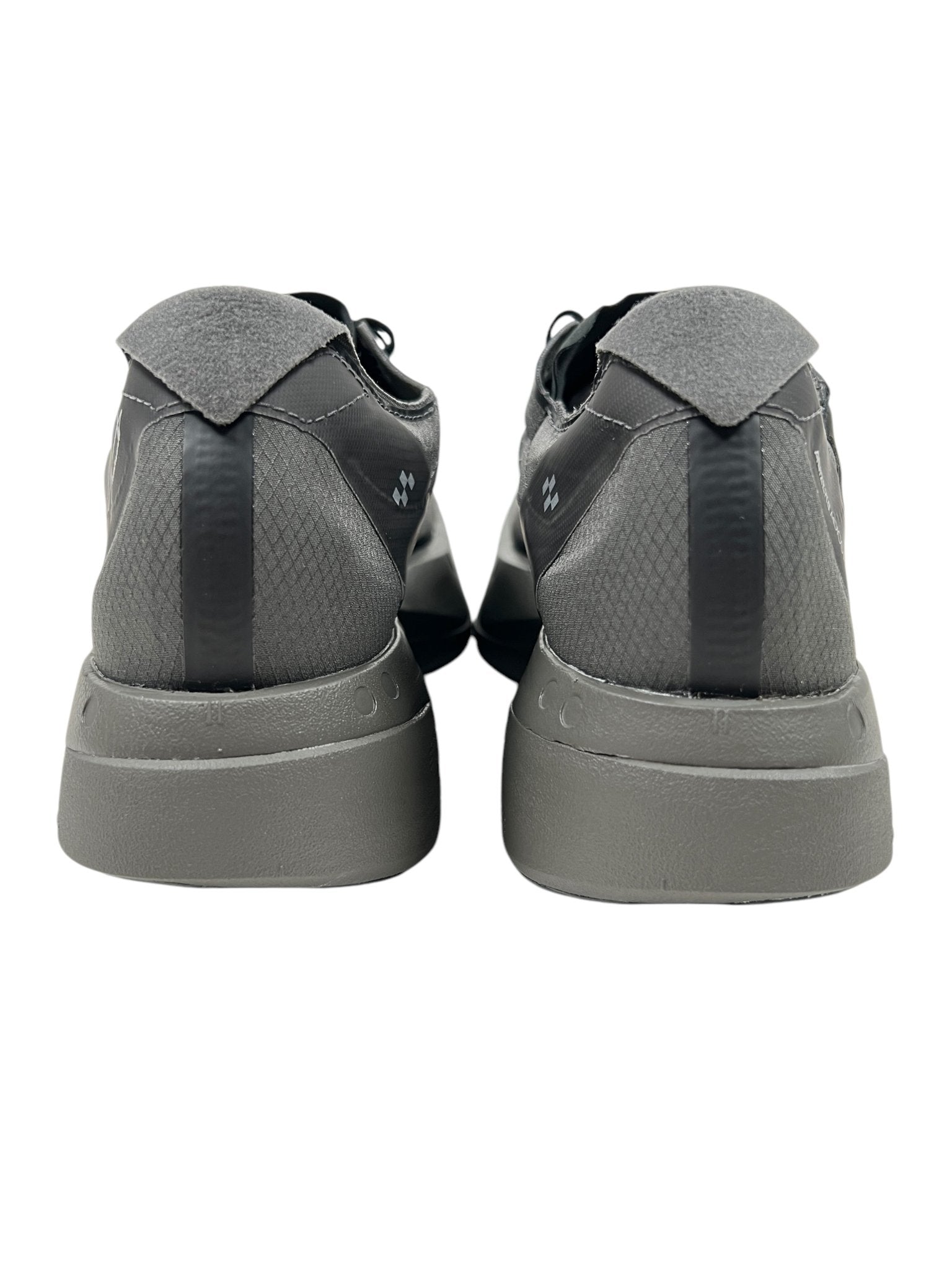 A rear view of ADIDAS x Y-3's Y-3 JS3155 Adios Pro 4 M sneakers in Cinder/Black showcases textured patterns and black accents. The cushioned soles provide comfort, and the iconic 3-Stripes logo offers a signature touch.