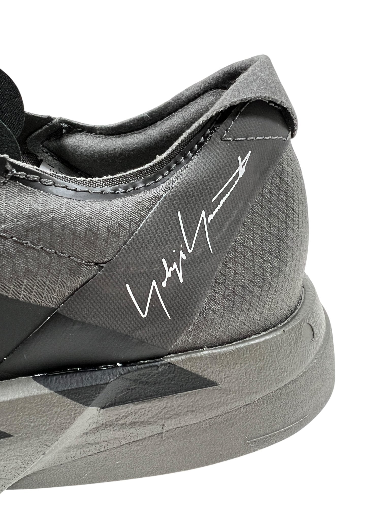 Close-up of an ADIDAS x Y-3 JS3155 Y-3 Adios Pro 4 M heel in Cinder/Black with a black and white pattern, showcasing the iconic 3-Stripes logo and a white signature on the side.